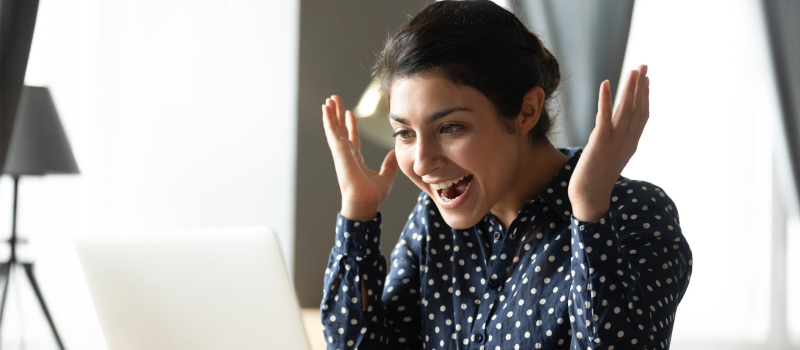 Excited indian girl amazed with good online news